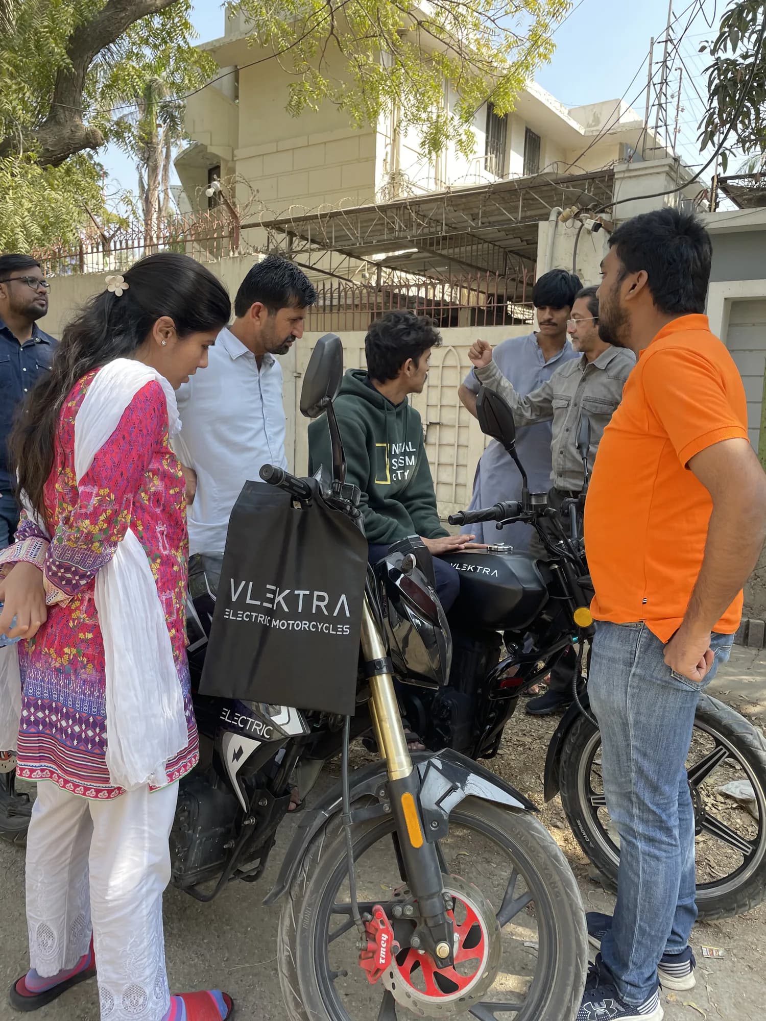 Visitors learning about an electric motorcycle at an EV event