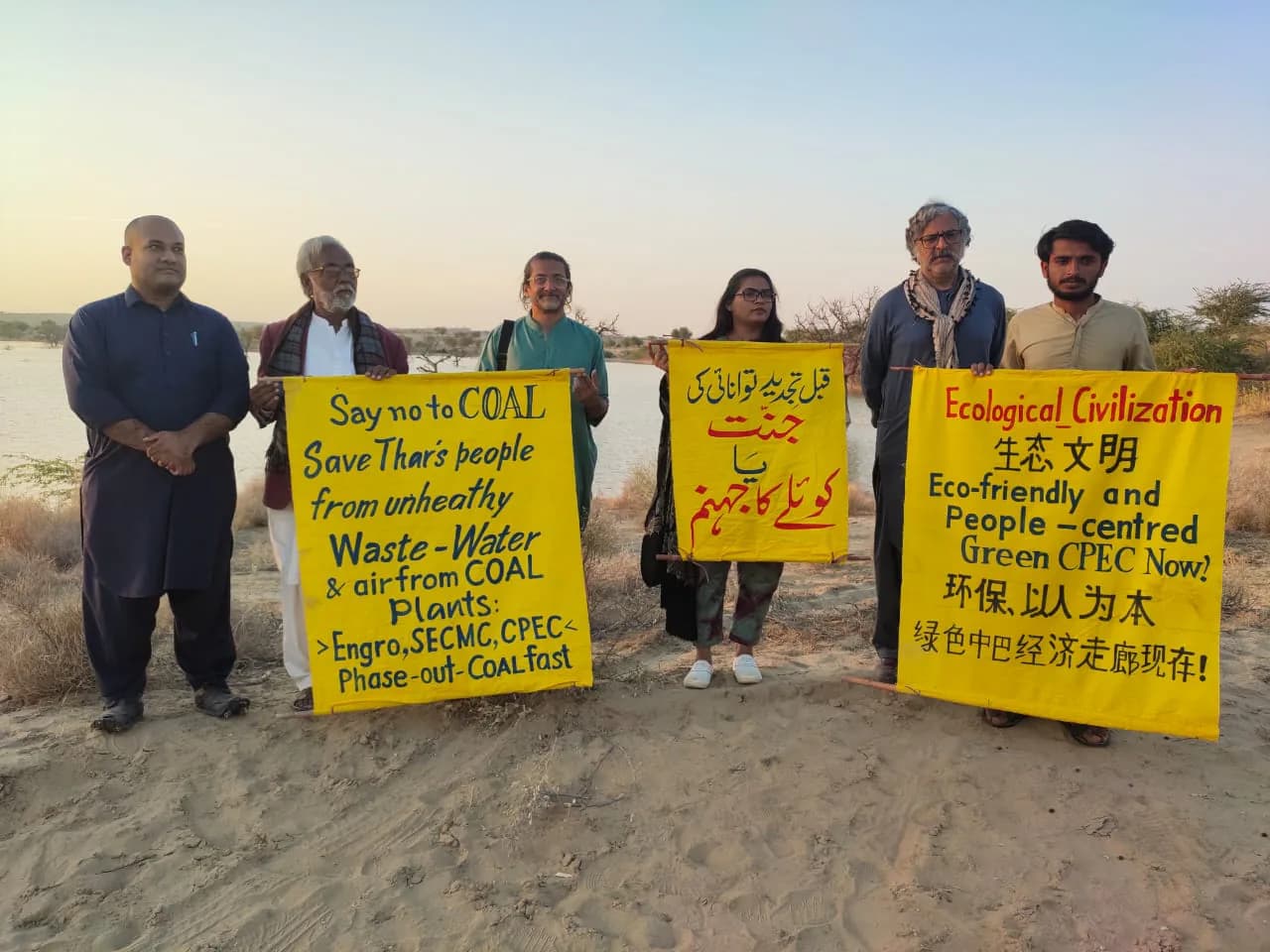 Climate advocates holding multilingual signs for clean energy and ecological action
